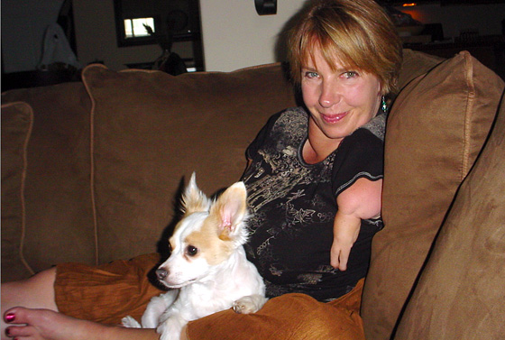 Sabine Becker on her couch with white dog
