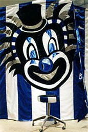 A detail shot of the blue and white striped stool and blue and white striped fabric chamber adorned with a giant clown face.