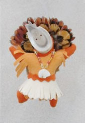 another small doll-like fetish with a headdress of feathers, beaded necklace, mask and dress made of leather. This one appears to have a bone bear fetish on its necklace.