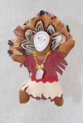 a small doll-like fetish with a headdress of feathers, beaded necklace, mask and dress made of leather.